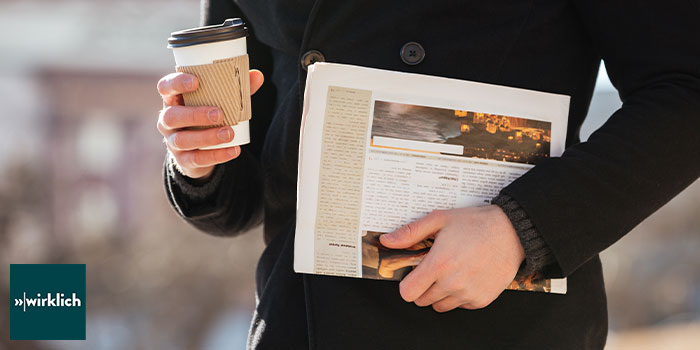 Person hält Zeitung und Kaffee – Symbolbild für modernen Lokaljournalismus und tägliche Informationskultur.