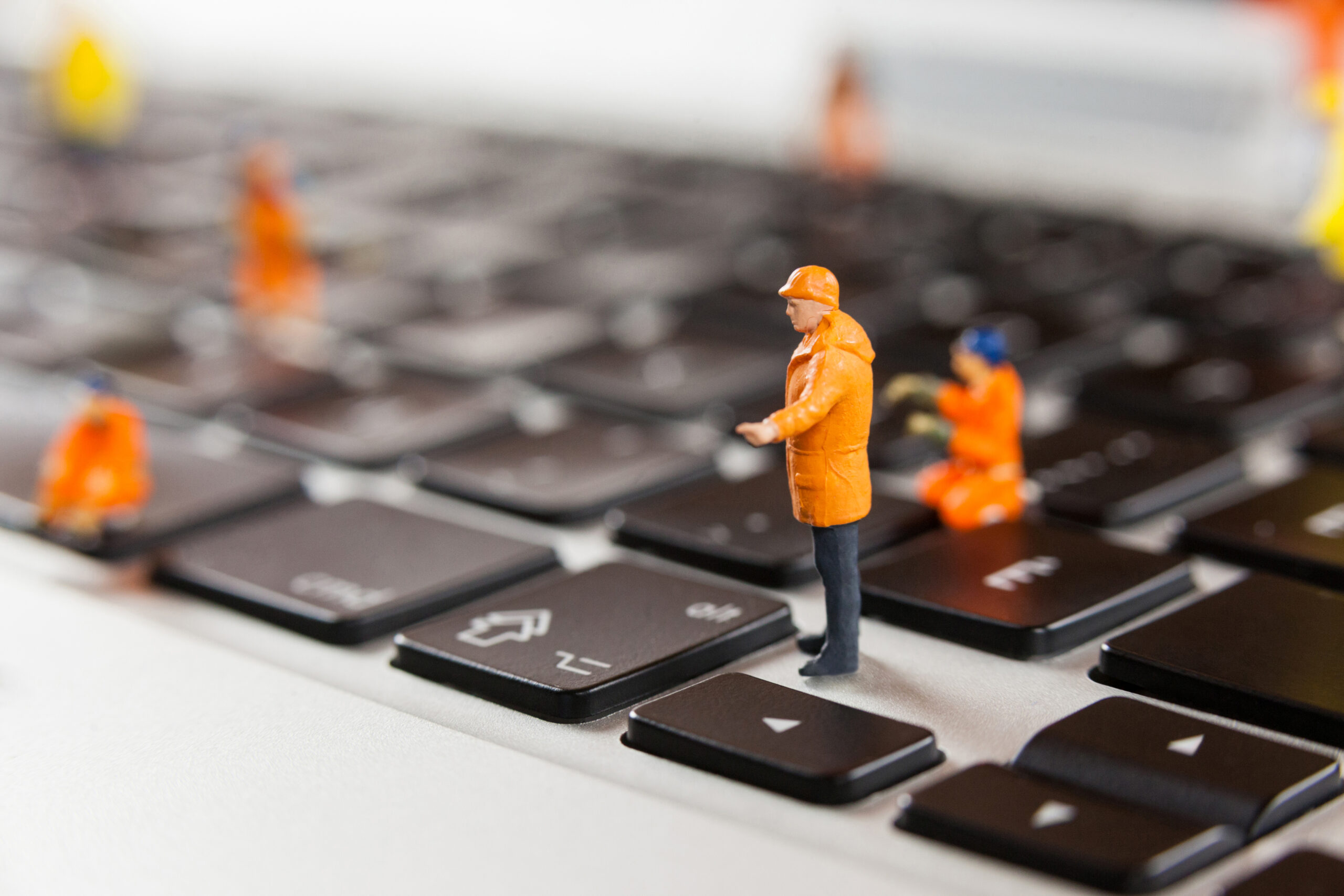Funktionsfähiger Staat: Miniaturfiguren auf einer Tastatur symbolisieren digitale Verwaltung und modernen Bürokratieabbau.